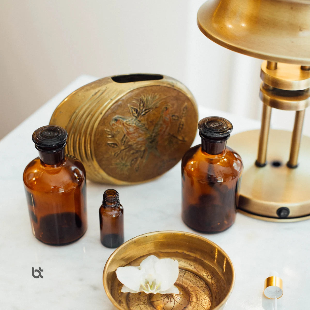 Kliniğin sıcak atmosferini tamamlayan vintage amber şişeler ve pirinç detaylar.